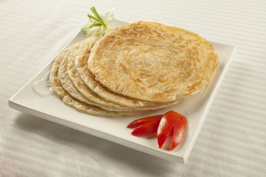 Plain paratha puri served with freshly sliced tomato and cucumber 