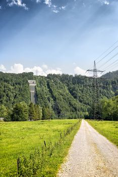 View to tubes of a hydroelectric power plant on the hill with trees on Lake Kochelsee, Bavaria, Germany