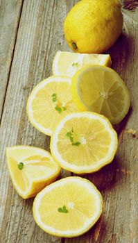 Ripe Raw Lemons Full Body, Halves and Slices In a Row on Rustic Wooden background