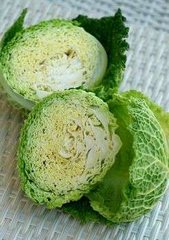 Halves of Green Leafy Texture Savoy Cabbage closeup on Wicker background