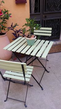 Garden chair and table with tree in pot
