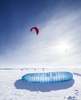 Kite surfer being pulled by his kite across the snow