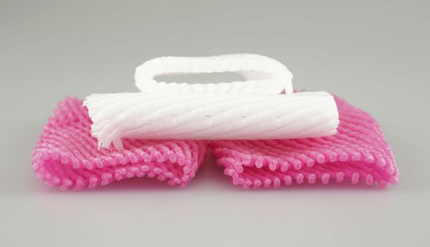 Pink and white foam fruit net for packaging the fruits placed on table.                          