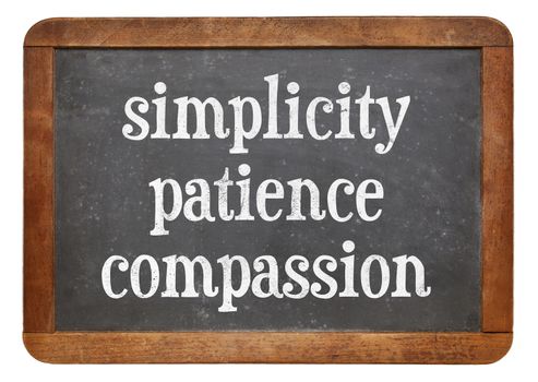 Simplicity, patience and compassion - three words from Buddha teaching on a vintage slate blackboard