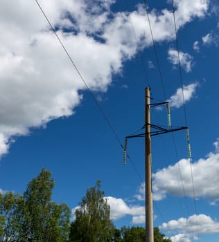 Power lines and trees on blue sky background