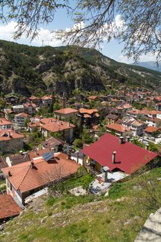 Top view of a small town wtih old buildings, the roofing tiles of historical Mudurnu houses, among mountains, under cloudy sky.