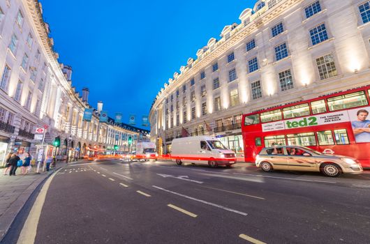 LONDON - JUNE 15, 2015: Buses and traffic in Regent Street at night. London attracts 50 million people across the world.