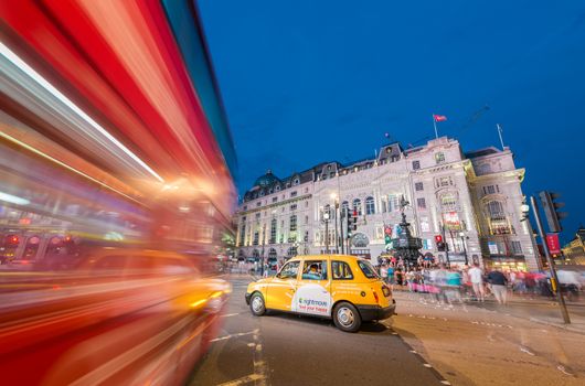 LONDON - JUNE 15, 2015: Buses and traffic in Piccadilly Circus at night. London attracts 50 million people across the world.