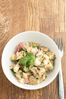 Potato salad freshly homemade without mayonaise.  Ingredients include cilantro olive oil vinegar whole grain dijon mustard red onions and potatoes. 