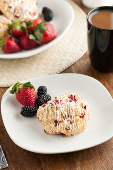 Orange Cranberry Scone with fresh fruit.  Shallow depth of field.