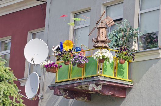 balcony with various decorations in city. flowers and windmill model