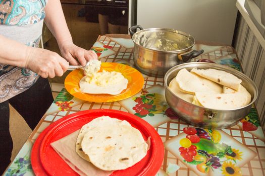 The hostess cooks kastyby with mashed potatoes on the kitchen table  