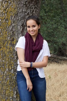 Attractive young teenage girl posing for senior portraits in a park