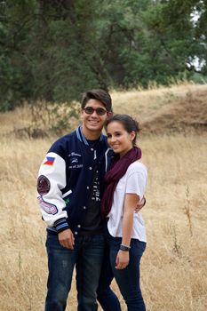 Happy teen couple standing in a meadow