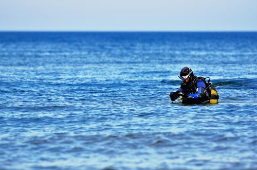 Scuba diver preparing to dive into sea