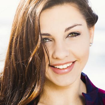 Portrtait of a happy girl at the beach smilling 