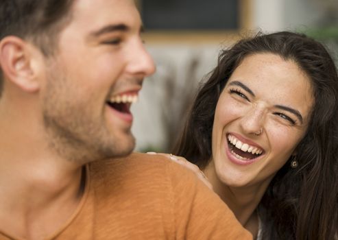 Happy couple at the restaurant talking and smiling