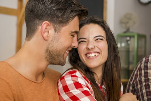 Happy couple at the restaurant talking and smiling