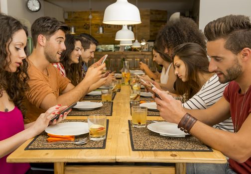 Group of friends at a restaurant with all people on the table occupied with cellphones