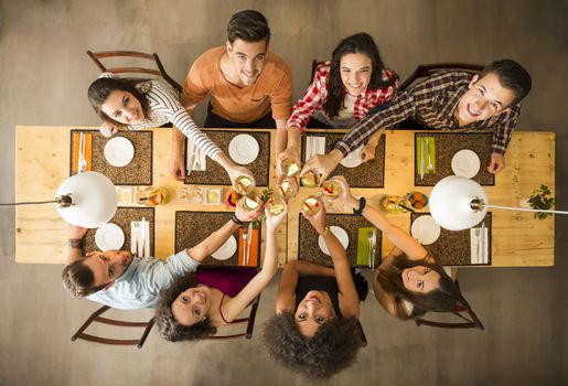 Group of people toasting and looking happy at a restaurant