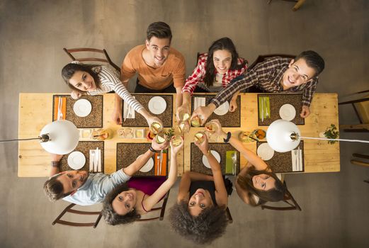 Group of people toasting and looking happy at a restaurant