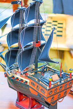 
Detailed model of a sailing vessel with blue sails and a piracy flag.