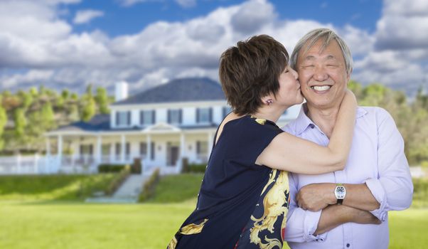 Attractive Affectionate Senior Chinese Couple In Front of Beautiful House.