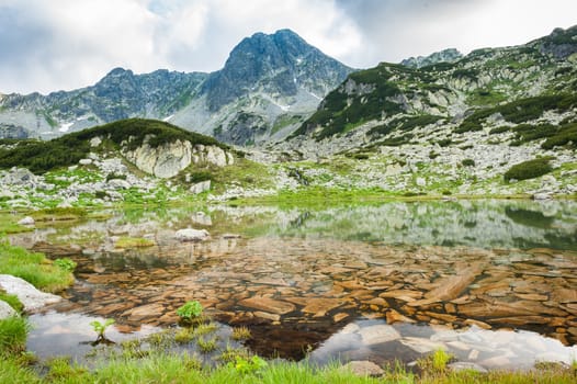 Small mountain lake in Retezat National Park, Transylvania, Romania, Europe. Stones under transparent see-through water.