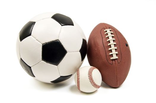 Horizontal shot of a baseball, soccer ball, and football.  On white background