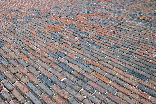 Angled shot of a very old brick lined street