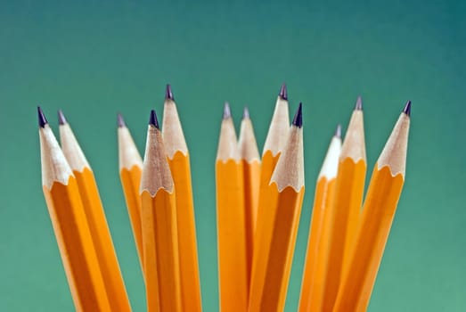 Horizontal shot of a group of yellow pencils on a green background