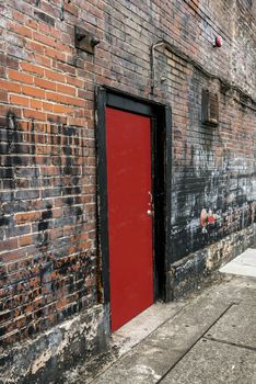 A bright red door in an old brick wall