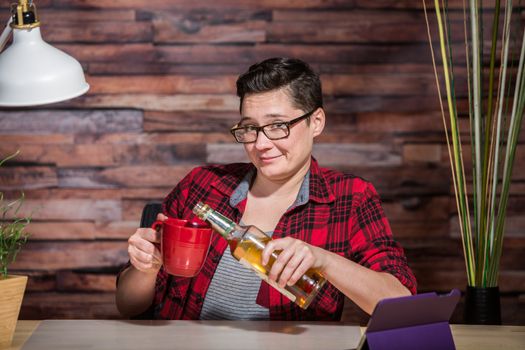 Grinning woman pouring whiskey into coffee mug