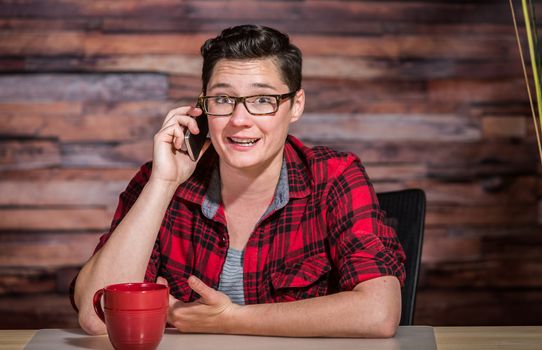 Happy lesbian corporate worker in casual shirt on phone