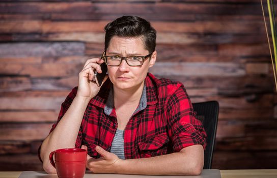 Mad office worker at modern desk office on phone