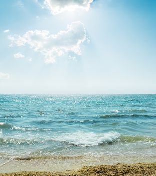 wave on sea and blue sky with clouds and sun