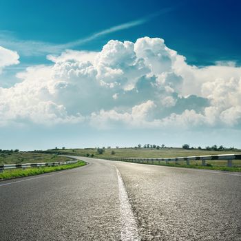 asphalt road to horizon and clouds over it