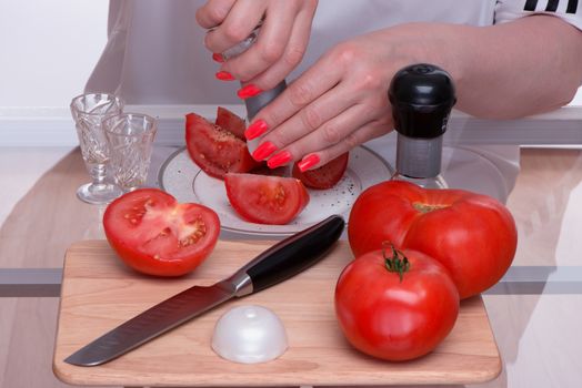 Tomatoes are sliced and salted also by pepper