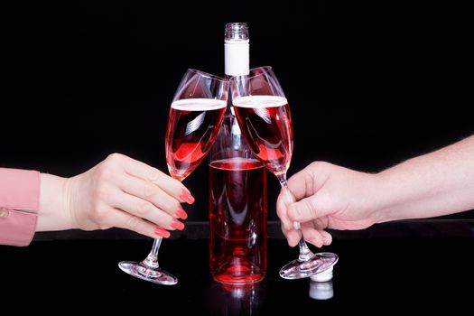 Male hand and female hand with manicure hold glasses with red wine