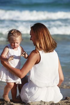 Happy mother holding her daughter on the beach. Mallorca