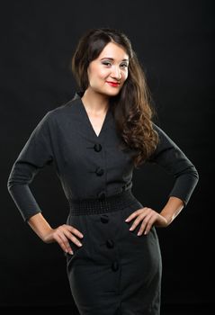 Beautiful brunette girl with bright makeup and curls. Picture taken in the studio on a black background.