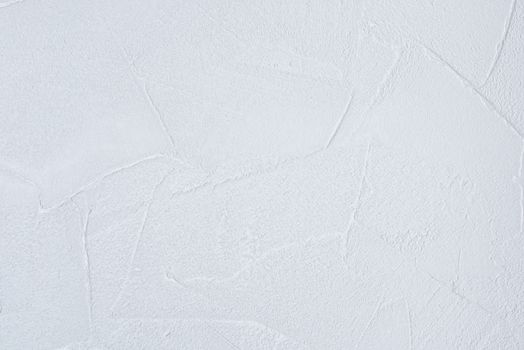 The texture of a white wallpaper designed to look like plaster.