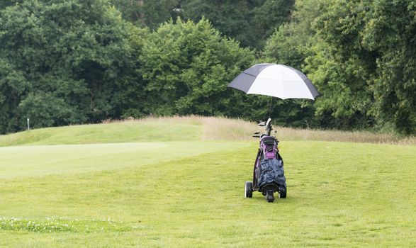 golfcar with clubs in bag on the golfcourse