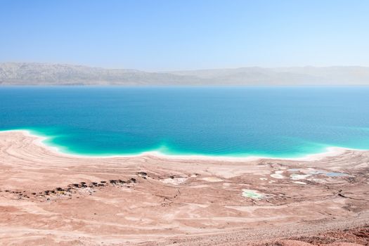 Aerial view Dead Sea coast in desert landscape with therapeutic curative mud and mineral salt 