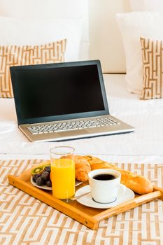 laptop and breakfast tray in bed hotel