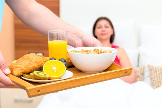 tasty and healthy breakfast on a tray in bed