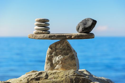 Well-balanced of pebbles on the top of sea boulder