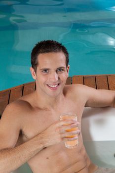 Man inside a jacuzzi drinking juice