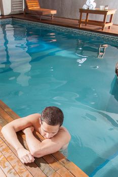 Guy rest in the edge of the pool