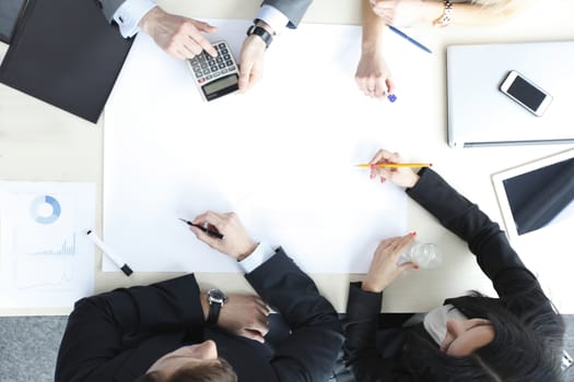 Business people sitting at table with electronic devices on meeting